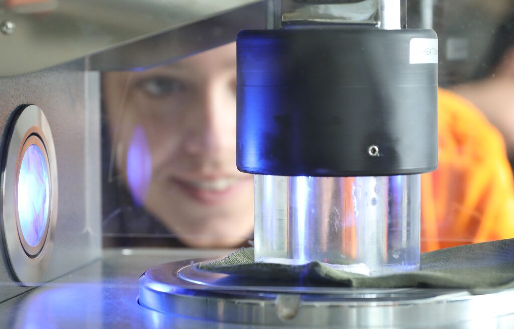 Machine textile en premier plan avec un chercheur en arrière-plan