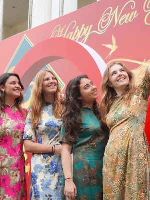 des étudiantes de l'ENSAIT posent devant une affiche du nouvel an vietnamien à DonghA